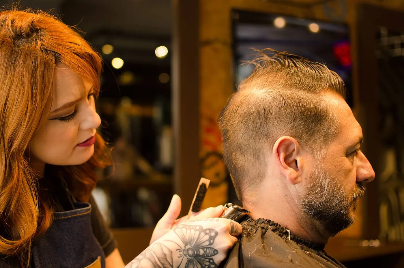 Profissional realizando acabamento de cabelo e barba